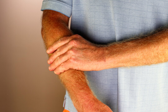 Left Hand and Fingers of an Adult White Male Massaging His Forearm