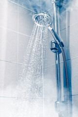 Naklejka na ściany i meble contrast shower with flowing water and steam, blue background