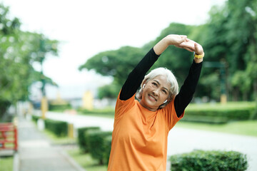 Athletic Senior woman stretching arms in park.