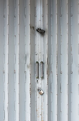 Locked classic foldding metal gate of old shop