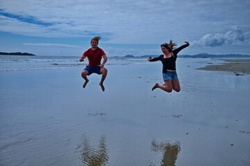 Mature couple jumping on the beach and having fun