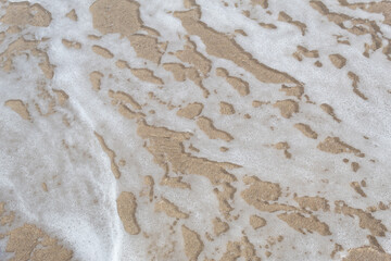 Sea water puddle background on beach sand