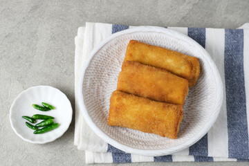 Risoles Rogout, Indonesian traditional savory snack. Filled with chicken chopped and mix vegetable, covered with bread crumb and deep fried. Served in white plate with chilli.
