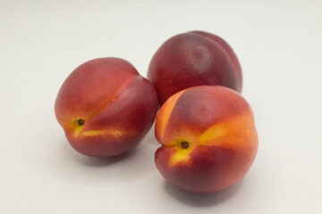 three nectarines on a white background
