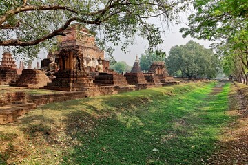 Sukothai Historical Park, a UNESCO world heritage site, with view of huge ancient Buddha statues among ruins of Temple Wat Mahathat surrounded by fresh greenery ~ Beautiful scenery in Thailand