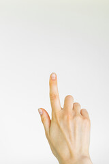 a female hand points a finger at an empty space on a gray background. empty space for text, business concept
