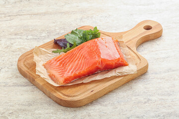 Raw salmon fillet over board