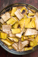 cut banana peels pieces soaked in water, food waste used as natural fertilizer, kitchen waste management concept, cheap and eco friendly organic compost, taken from above