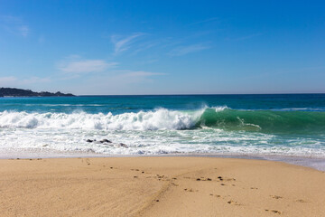 A view on Pacific ocean coast with blue sky and water and waves © Polina Korchagina