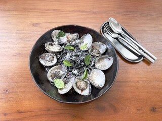 Squid ink pasta vongole with spices and herbs. Famous Traditional Italian food, black pasta, top view