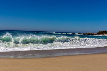 A view on Pacific ocean coast with blue sky and water and waves