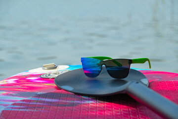 Paddle and sunglasses on SUP paddle-board