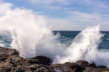 A view on Pacific ocean coast with blue sky and water and waves