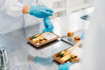 お弁当の盛り付けをする作業員（食品加工・盛り付けスタッフ）
