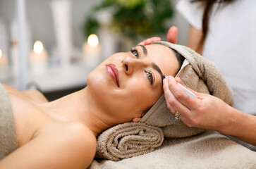 Obraz na płótnie Canvas Woman having eyebrows treatment in spa salon