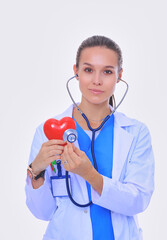 Positive female doctor standing with stethoscope and red heart symbol isolated. Woman doctor