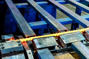 Machine for induction heating of metal. A metal rod heated in an induction furnace. Hot metal processing. Metalworking in the industrial workshop at the factory.