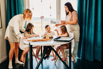 Big family with two moms cooking with their children cookies. Loving people and happy childhood hobbies