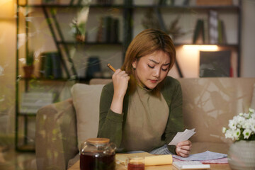 Sad desperate young woman checking her monthly spendings and loan payments