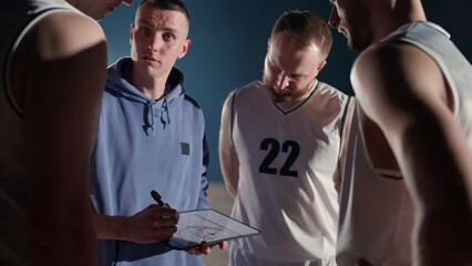 Basketball championship, the coach instructs players on the tactics of game, using a tablet and a marker for drawing, briefing before the game, 4k slow motion. - Powered by Adobe