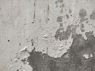 Obraz premium Abstract paint is peeling off the building wall.Close-up. Badly fixed building facade wall covered with cracks in stucco and paint. Missing patch of paint in the middle; crack with flappy.