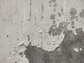 Abstract paint is peeling off the building wall.Close-up. Badly fixed building facade wall covered with cracks in stucco and paint. Missing patch of paint in the middle; crack with flappy.