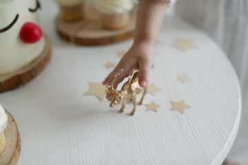 Cute little hand holding a Christmas deer figurine