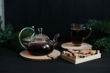 Brewed black tea in a glass teapot on a black table