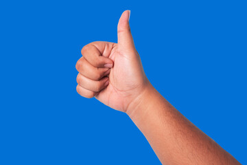 person's hand showing thumbs up, concept showing good appreciation, and okay or agree, isolated on blue background