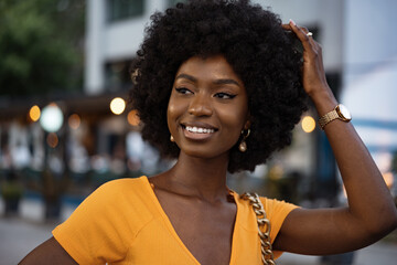 Portrait of a young african american woman smiling standing at the city.