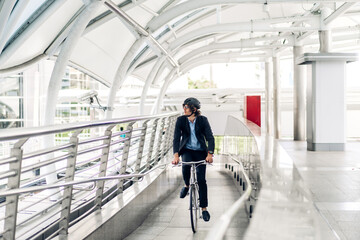 Portrait of hipster handsome businessman in suit with backpack looking forward while commuting riding bicycle on the street city way go to work.business travel transport bike concept