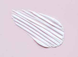 close-up cosmetic smear cream texture on pastel pink background