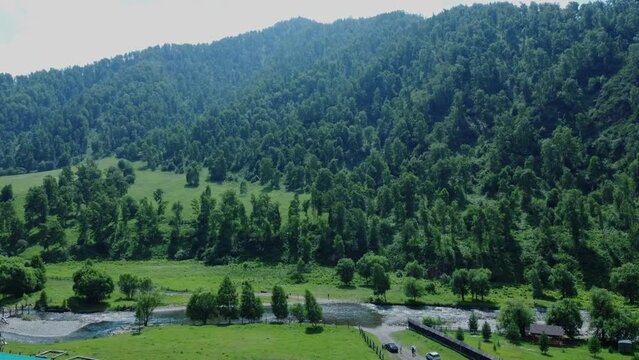 A mountain river flowing in the countryside among the green mountains. Aerial photography. Chemal, Altai Republic, Russia. High quality Full HD footage