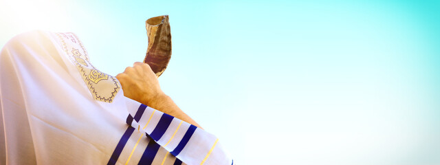 Jewish man blowing the Shofar (horn) of Rosh Hashanah (New Year). Religious symbol.