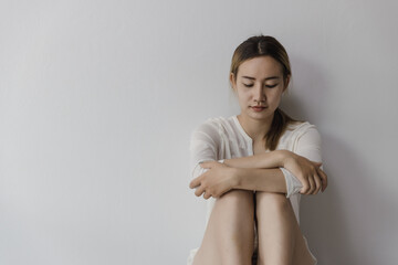 Asian woman sitting on the house area Feeling sad, tired and worried about depression, mental health problems and heartbreaking concept.