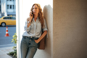 Young casual woman talking on the smartphone at the city