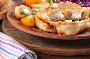 close-up pieces of tilapia fish in cheese batter lightly fried in olive oil. Front, close view