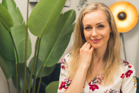 Caucasian Blonde girl in a room with a lamp and a plant. High quality photo