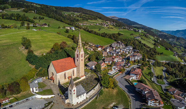 Villandro, Italy - Aerial view of the Church of St.Michael at the small village of Villandro (Villanders) on a sunny summer day with blue sky in Bolzano