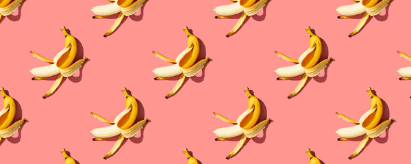 Yellow ripe bananas on pink background pattern, banner