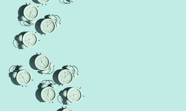 Top view of creative pattern made of blue alarm clocks on a blue background