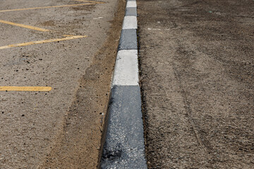 Obraz premium concrete curb. street border painted in white and black.