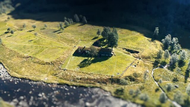 Aerial view of the traditional sod roof house on the river bank. Slow-motion. A tilt-shift video