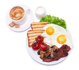 Fried eggs, bacon, tomato, toasted bread in ceramic plate and cup of coffee isolated on white background