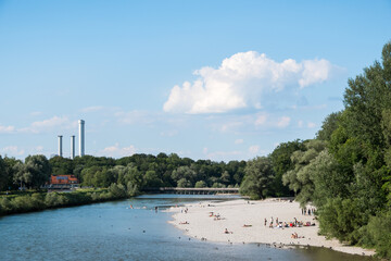 Blick auf Isar in München mit badenden Menschen im Sommer