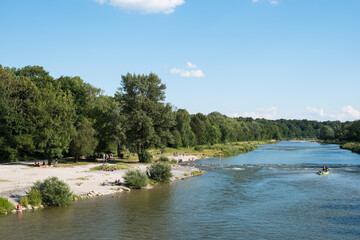 Blick auf Isar in München mit badenden Menschen im Sommer