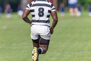 Rugby Player Running Close-Up Decapitated Rear Behind Game Action.