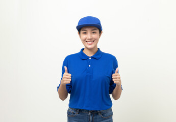 Happy delivery asian woman in blue uniform standing showing thumbs up on isolated white background. Smiling female delivery service worker.