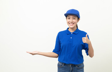 Happy delivery asian woman in blue uniform standing palm up hand to blank space for text advertise on isolated white background. Smiling female delivery service worker.