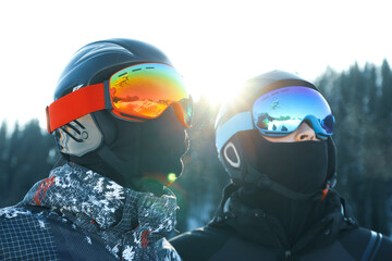 Male skiers in ski helmets and goggles in mountain resort
